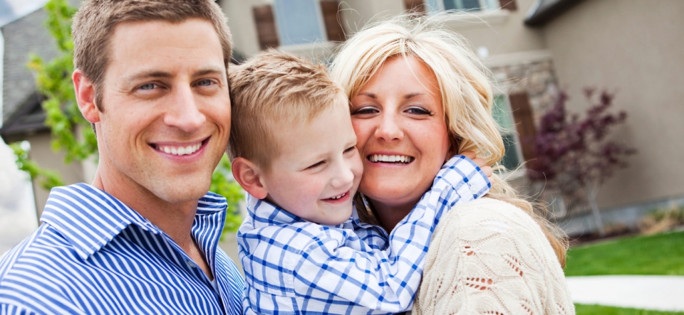 Family posing together in front of their house