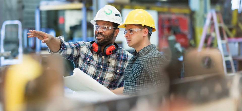 Workers in hard hats pointing forward