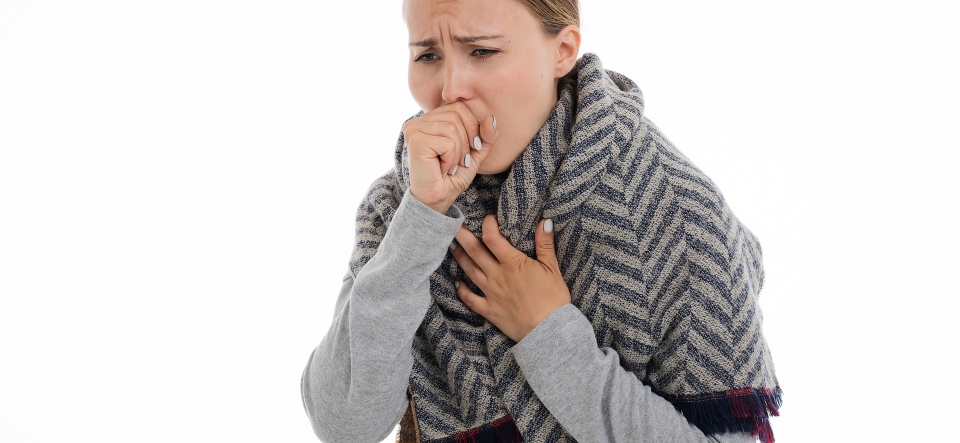 Woman coughing into fist