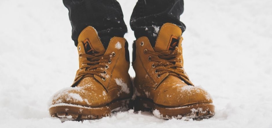 Worker boots standing on top of snow