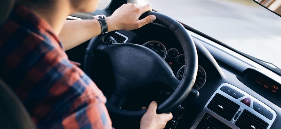 Person holding steering wheel in a car