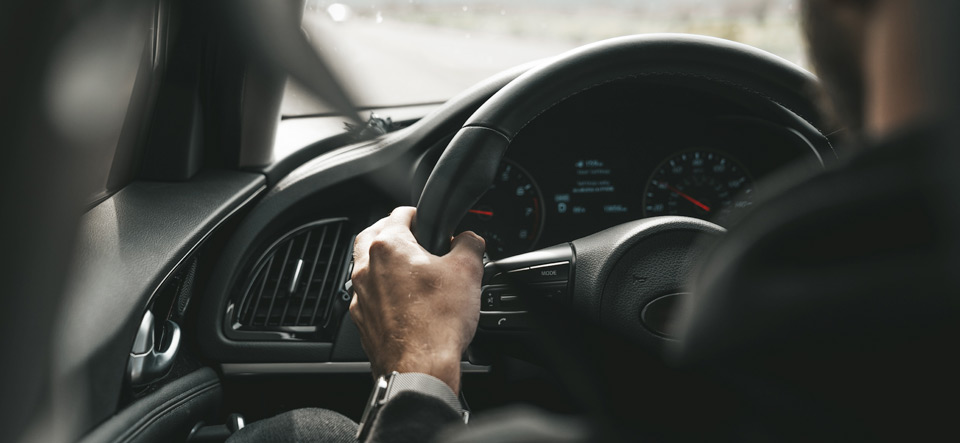 Man driving a car with hands in correct position on steering wheel