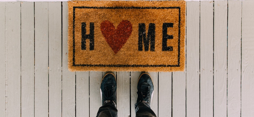 Welcome mat that says Home with a heart in it