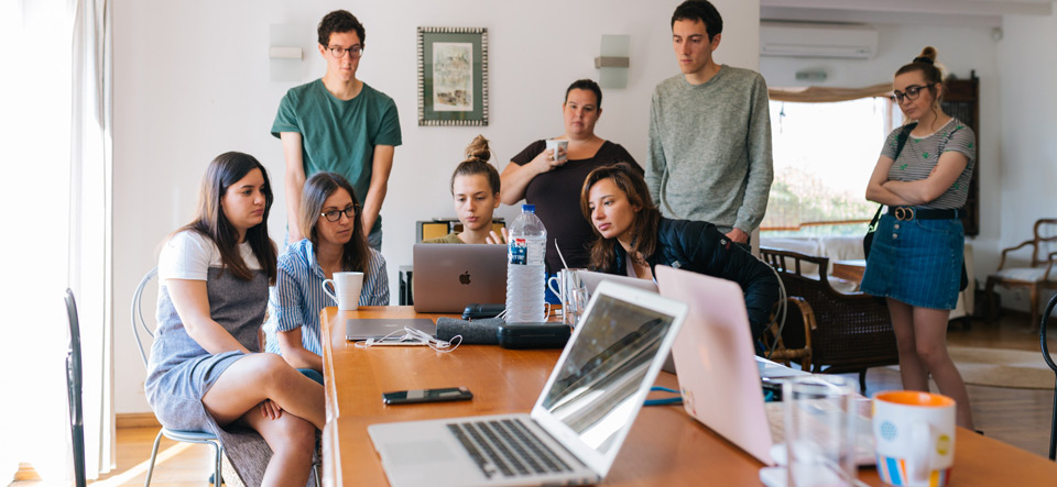 A small group of people collaborating together at a computer