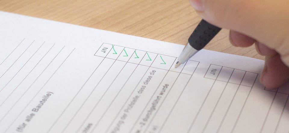 person filling out a checklist in pen