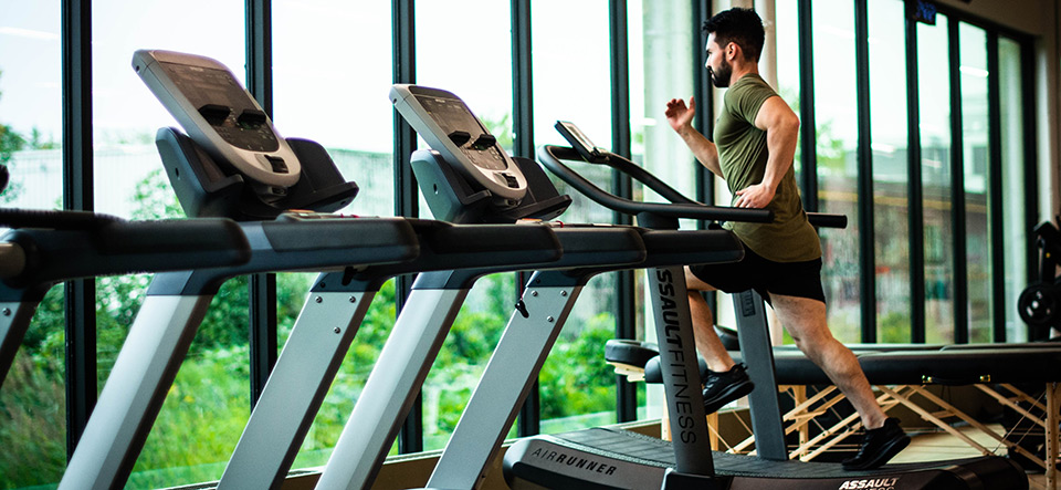 Man running on a treadmill alone in a gym
