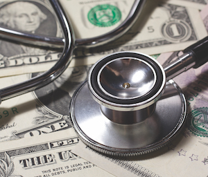Close-up of stethoscope and us dollar bills.