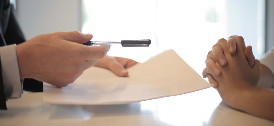 Two people writing and signing an agreement