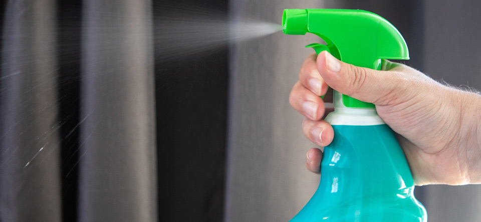 Hand spraying disinfectant from a spray bottle