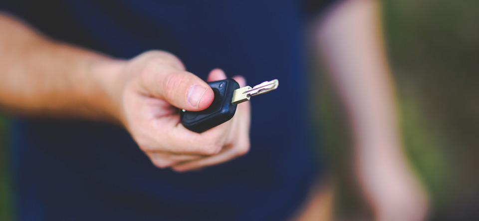 Parent presenting a car key to another driver