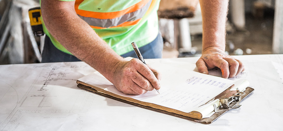 Construction worker filling out paperwork on a job site