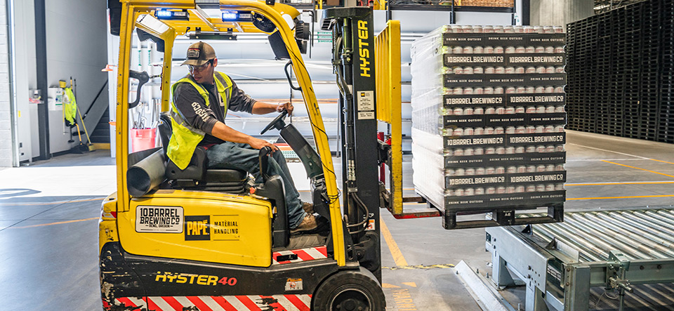 Worker driving a forklift in a warehouse