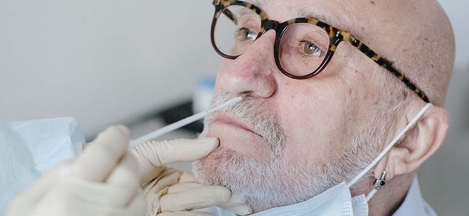 Man receiving nasal swab for COVID-19 testing