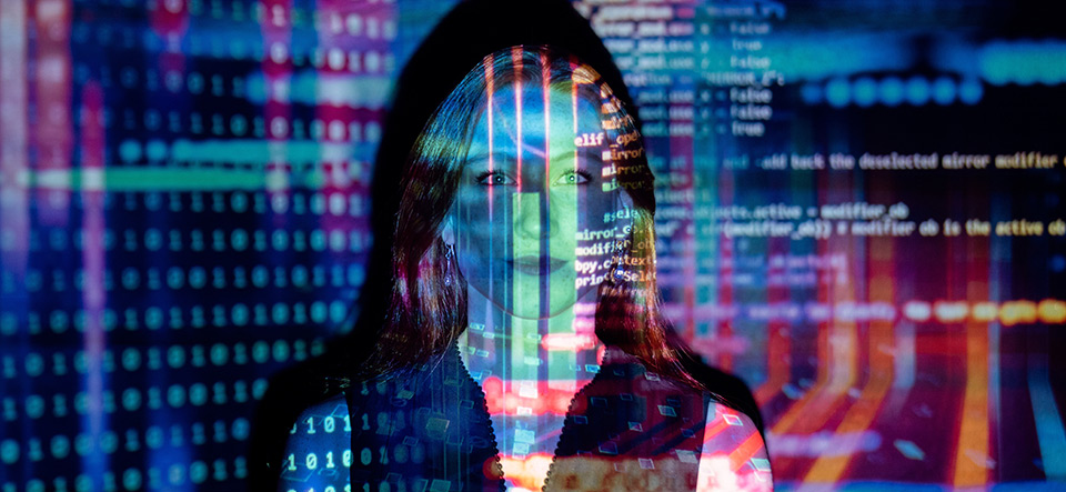 Woman standing in front of computer code projection