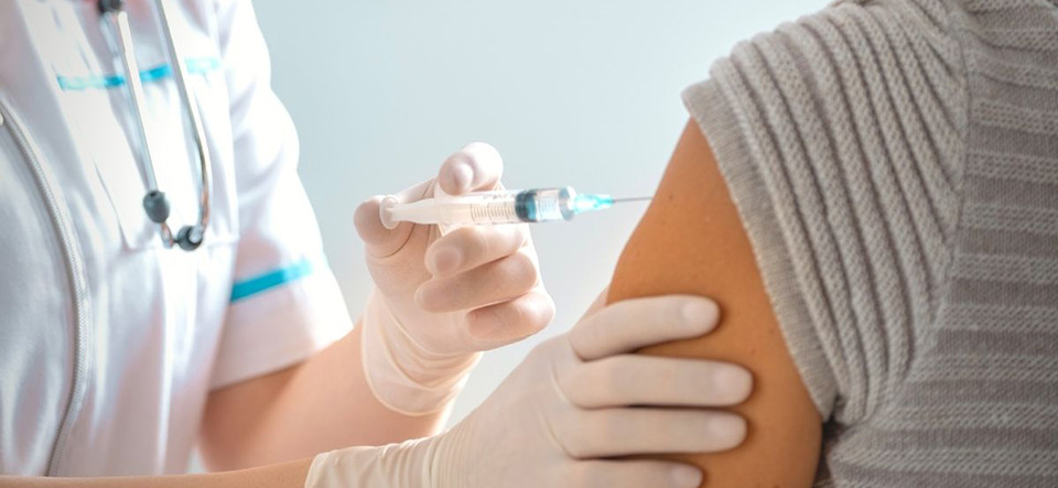 Person receiving a vaccine shot from a healthcare professional