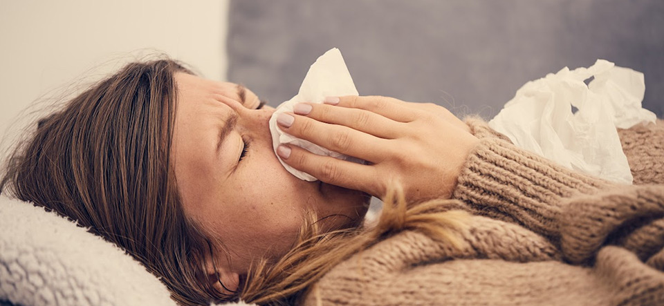 Sick woman blowing her nose