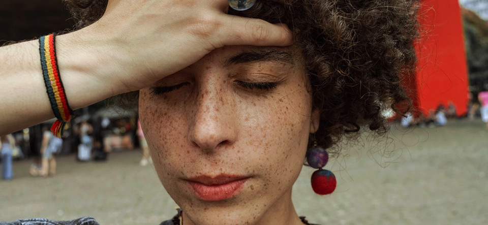 Freckled woman holding her hand to her forehead in dismay