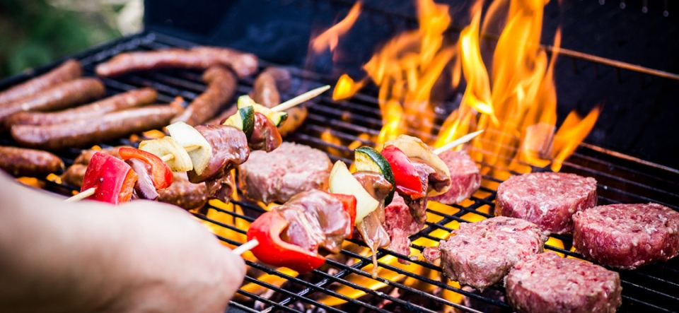 Detail Of Beef Burgers and sausages Cooking On A Barbecue