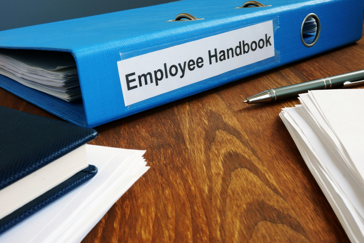 Employee Handbook manual in folder and documents.