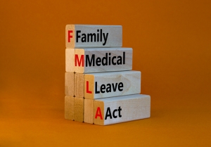 FMLA family medical leave act symbol. Concept words FMLA family medical leave act on wooden blocks on beautiful orange table orange background. Medical FMLA family medical leave act concept.