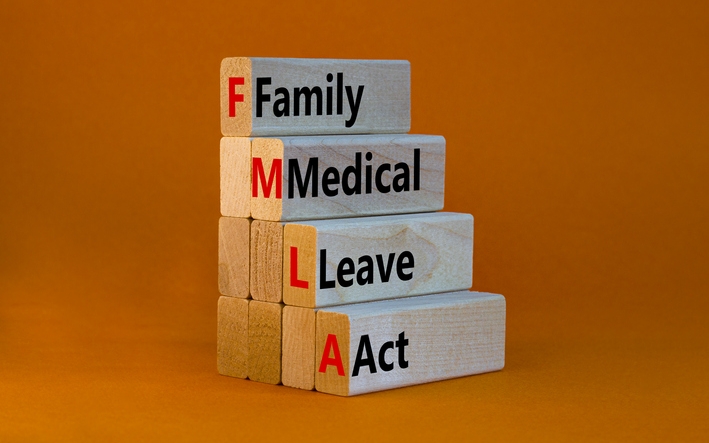 FMLA family medical leave act symbol. Concept words FMLA family medical leave act on wooden blocks on beautiful orange table orange background. Medical FMLA family medical leave act concept.