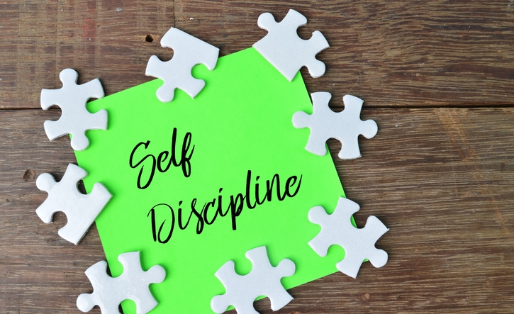 Jigsaw puzzle and memo note written with text SELF DISCIPLINE