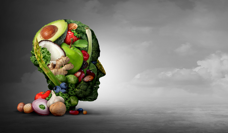 Vegan and vegetarian psychology concept with a group of fruit nuts beans and vegetable as an eating lifestyle and  thinking healthy diet as farm fresh produce shaped as a head in a 3D illustration style.