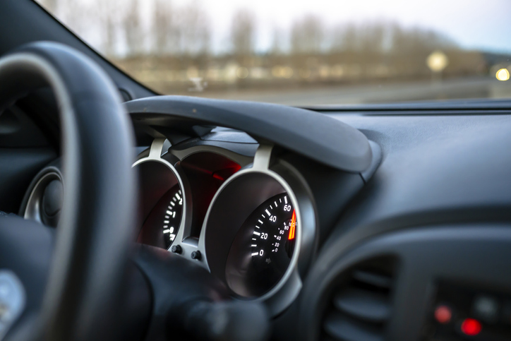 The speedometer of a crossover car with a gray interior with a luminous dial located on the information control panel shows the actual speed of the car on the road, flashing behind the windshield
