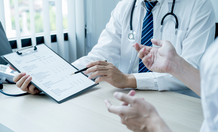The doctor hand pointing at the report and explained examination results to the patient man, healthcare and medical checkup concept.