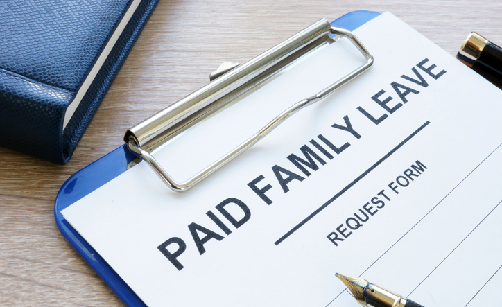 Paid family leave form in clipboard and note pad.