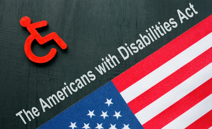 ADA or The Americans with Disabilities Act concept. A Disabled person sign and USA flag.