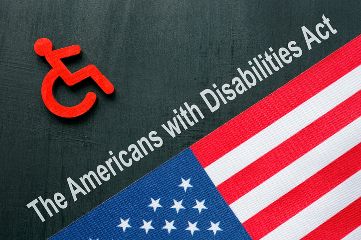 ADA or The Americans with Disabilities Act concept. A Disabled person sign and USA flag.