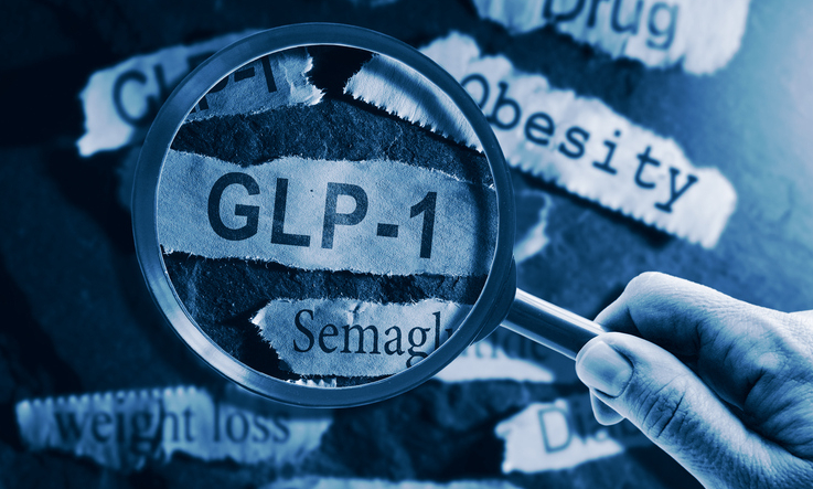 GLP-1 related drugs newspaper headlines with hand and magnifying glass